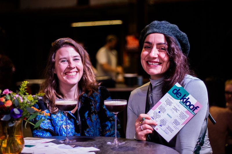 Young professionals onder het genot van een heerlijke cocktail, aan de slag met de bingokaart.